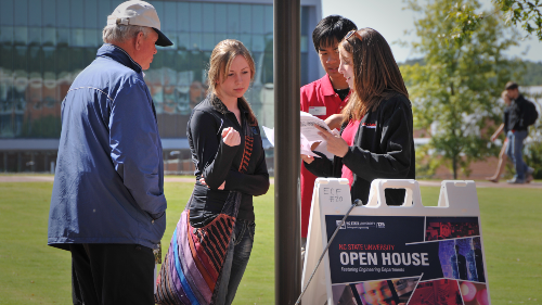 Image. A perspective student asks directions at an open house