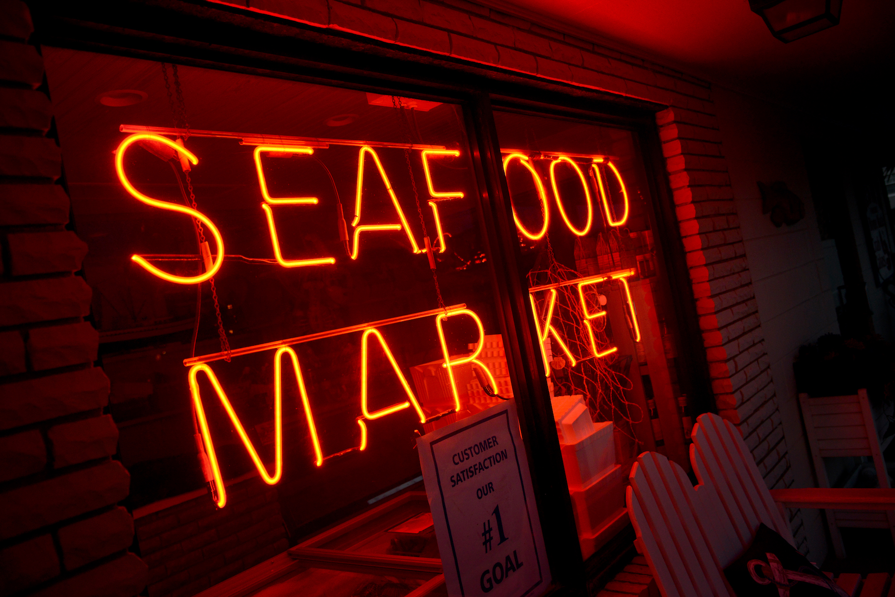 Red neon "Seafood Market" sign outside of a restaurant. 