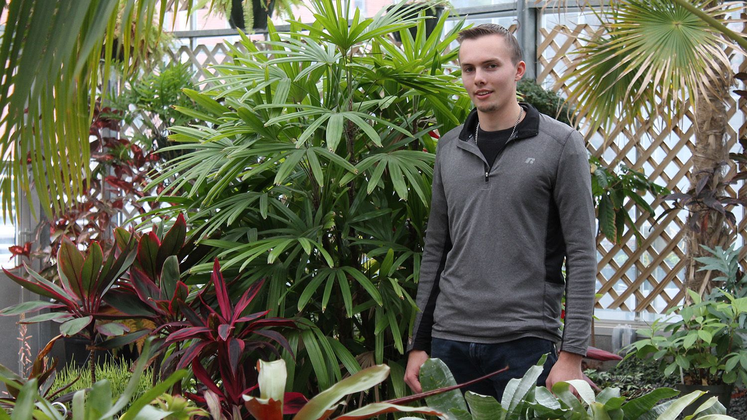 Student surrounded by tropical plants