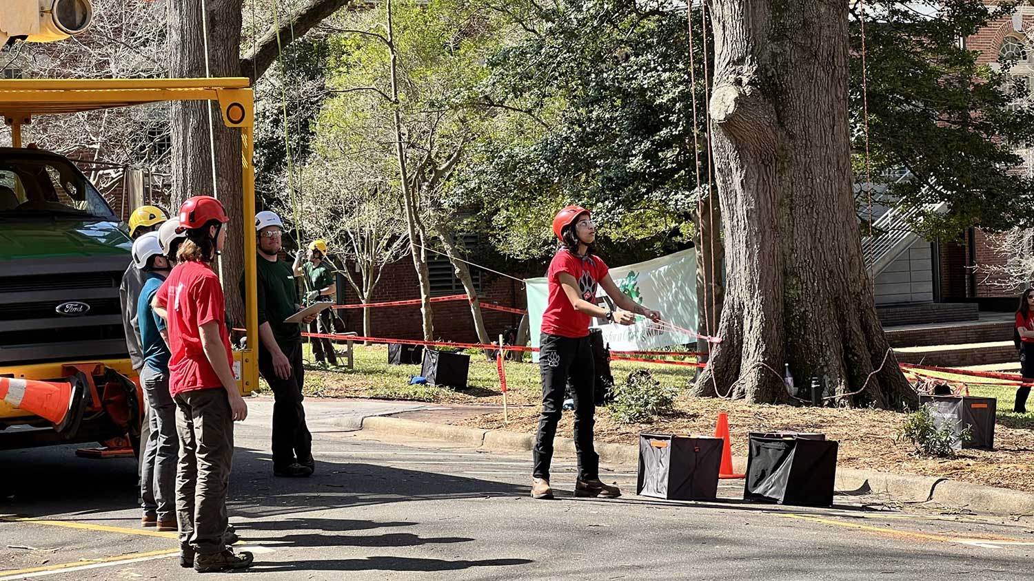 Roshni Panwala prepares a throwline in arboriculture techniques as teammate Williams Carrigan cheers her on.