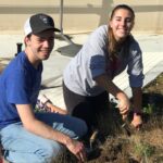 Connor Stone and Emily Gott plant purple pansies