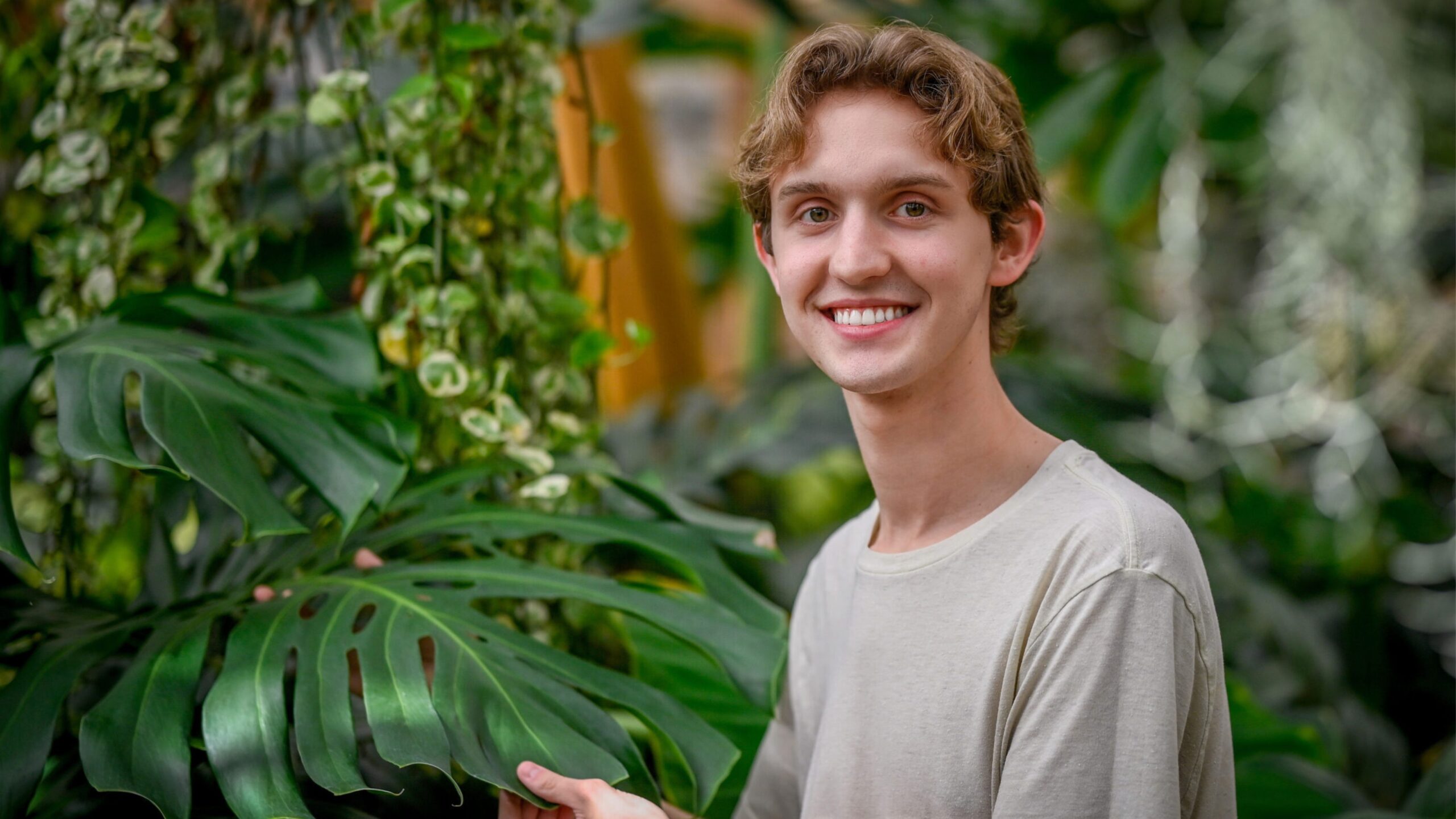 a male student in a greenhouse