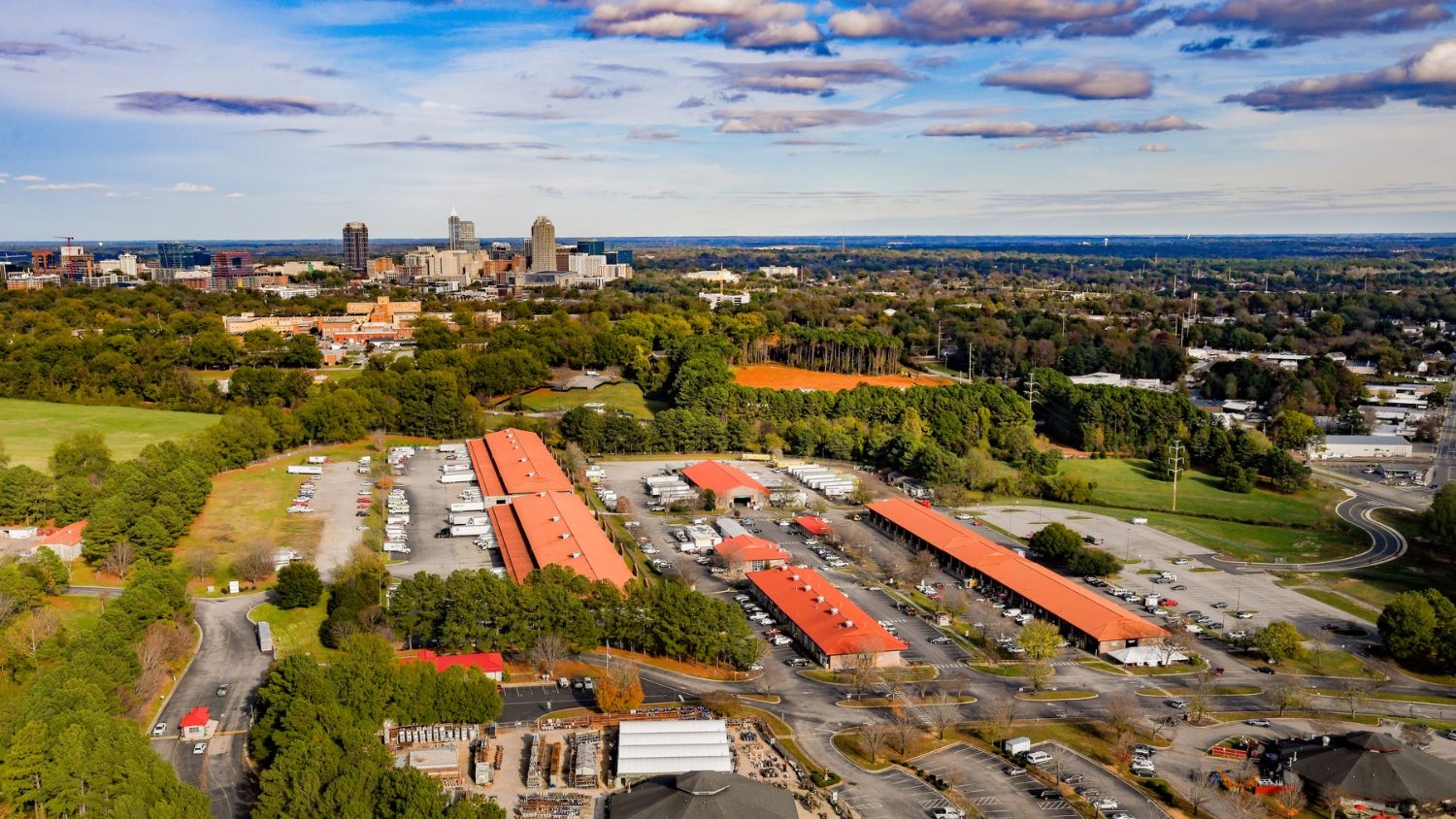 drone picture of North Carolina State Farmers Market with Raleigh skyline