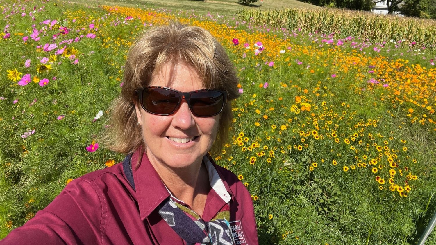 Debbie Hamrick taking a selfie in a field of flowers