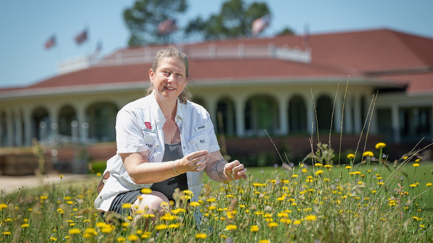 Danesha Seth Carley works in a pollinator garden in front of the clubhouse at the Pinehurst golf course.