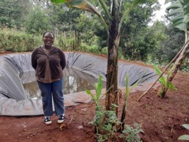 Joy Othoo next to plant