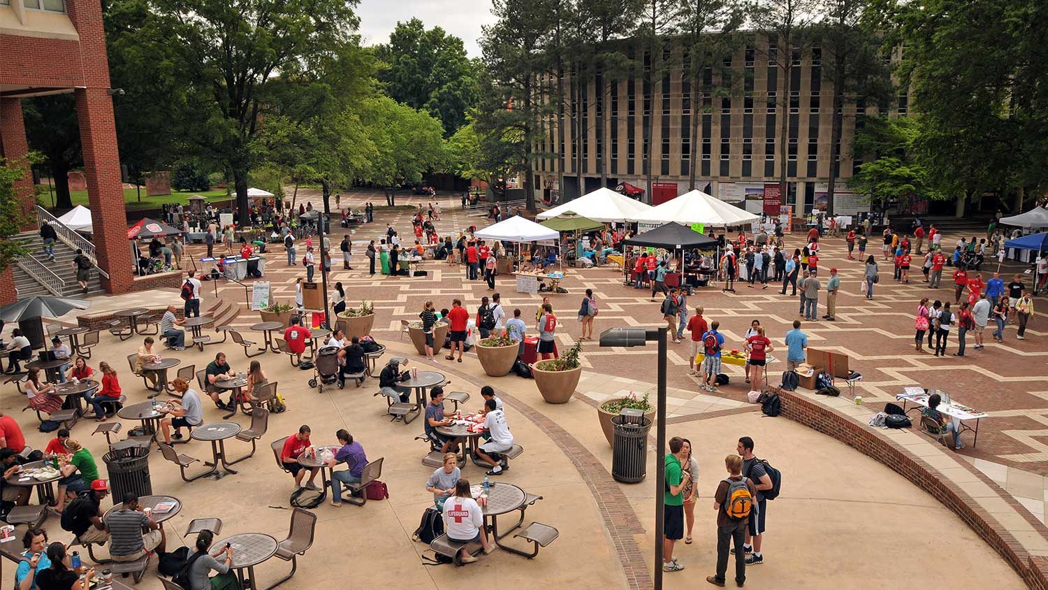 people sitting at tables with umbrellas