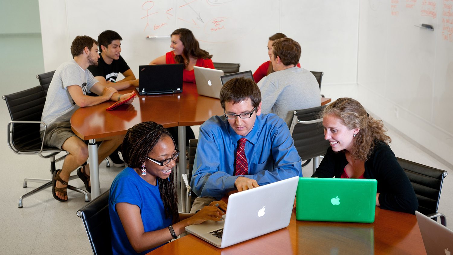 Faculty and students looking at a computer