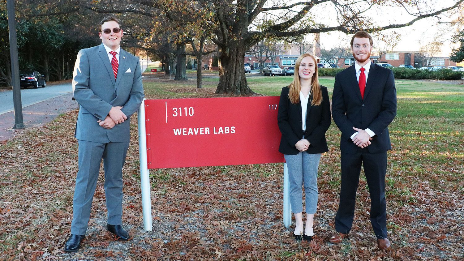 NC State students Matthew Parker, Lauryn Kabrich and Alex Greeson with the Weaver Labs sign.