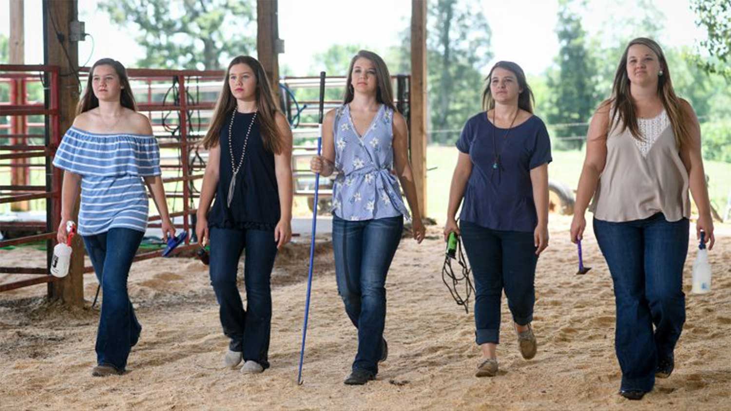 Five females walking with purpose in a barn