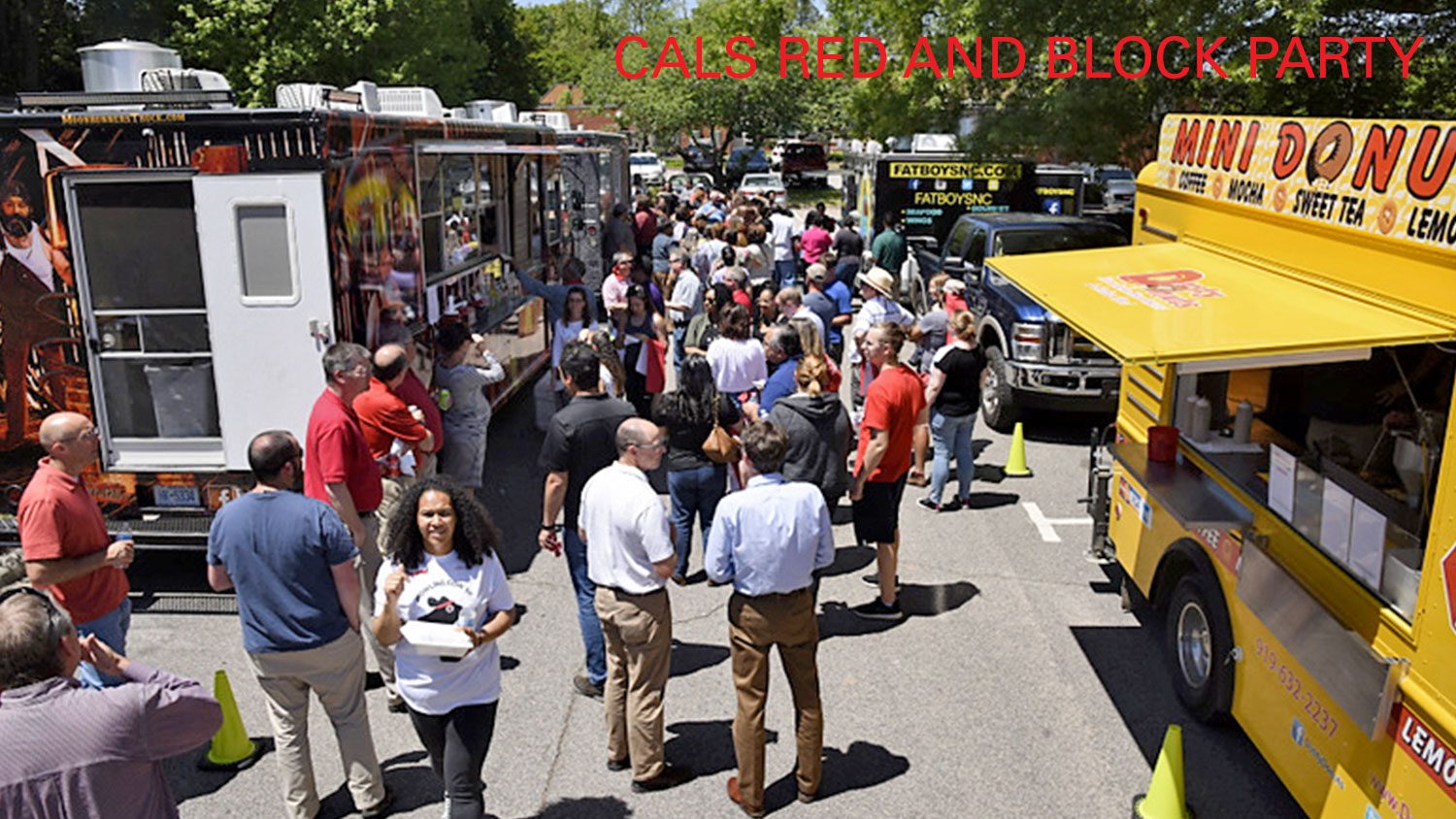 Food trucks and people waiting on line.