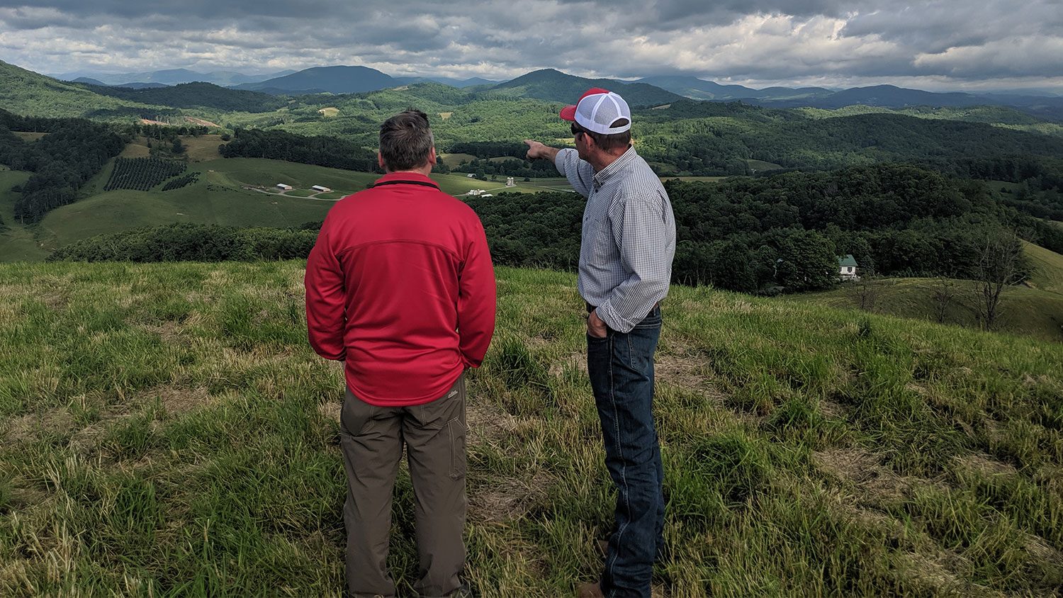 Two men looking out at a mountain view