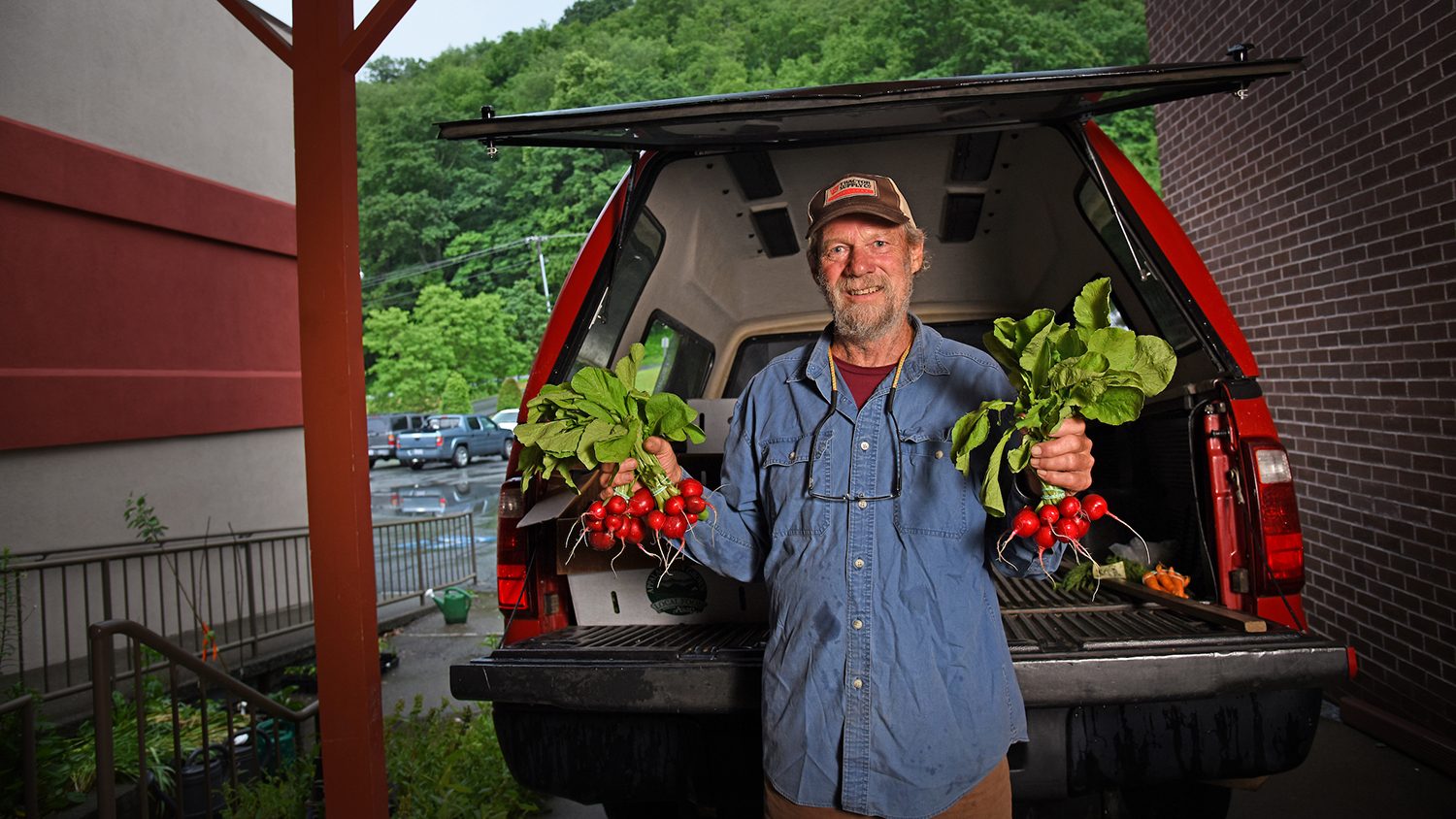 White man holding a plant in each hands.