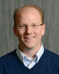 Headshot of white male with glasses