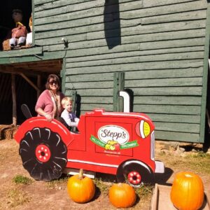 a woman and a little boy on a pretend tractor