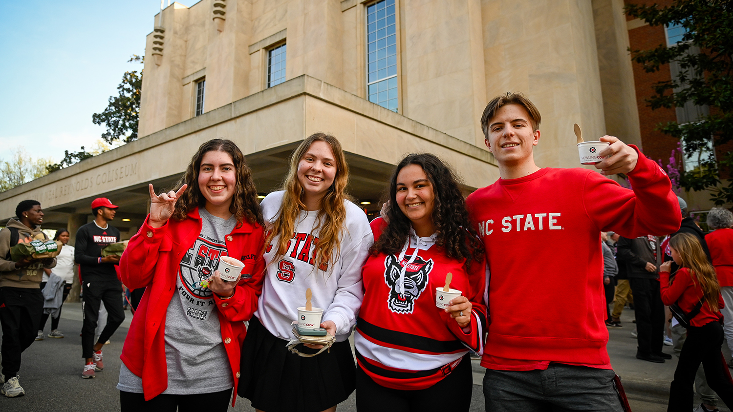 students wearing nc state shirts hold howling cow ice cream