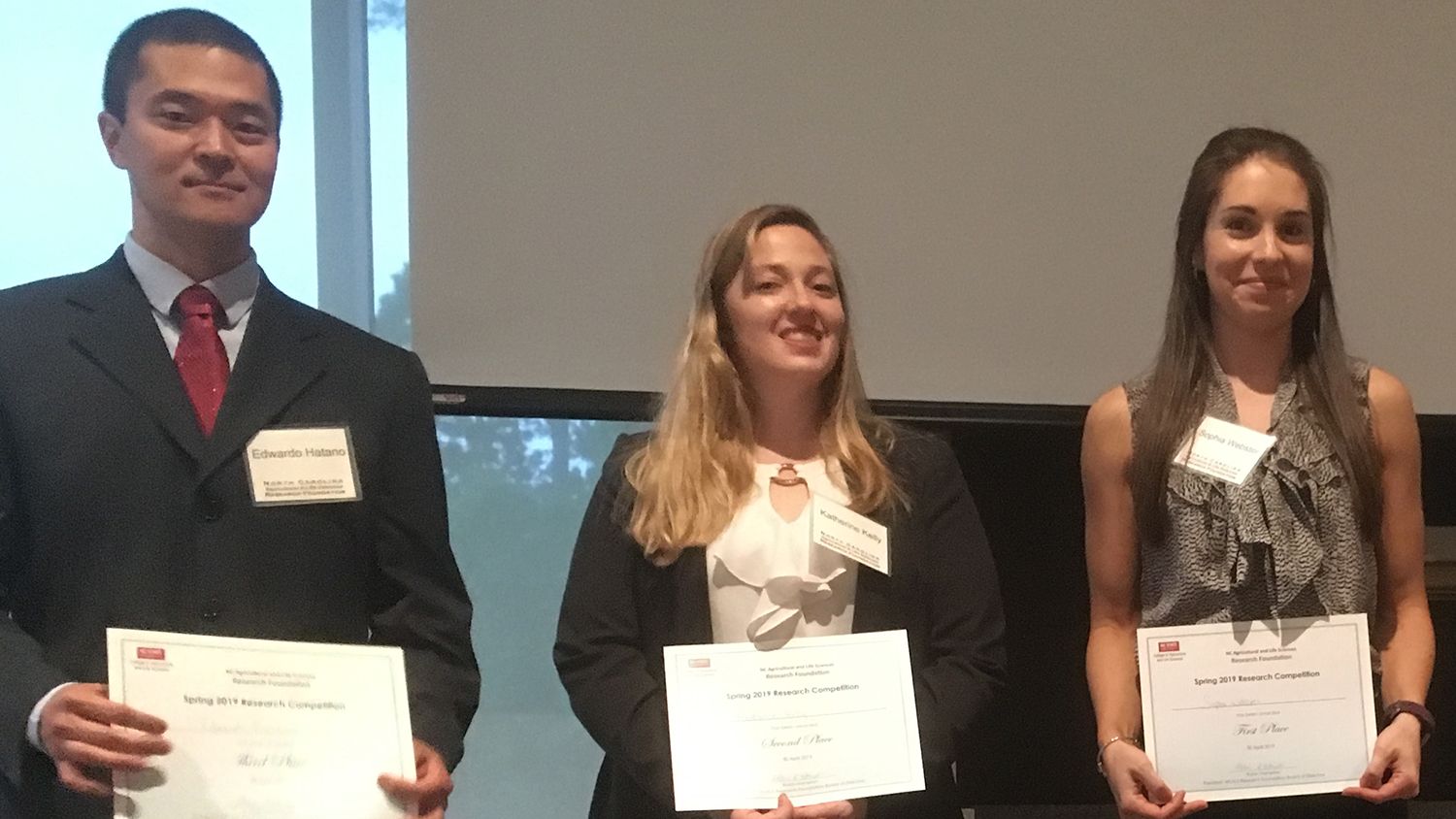 Pictures of two women and one man holding certificates.