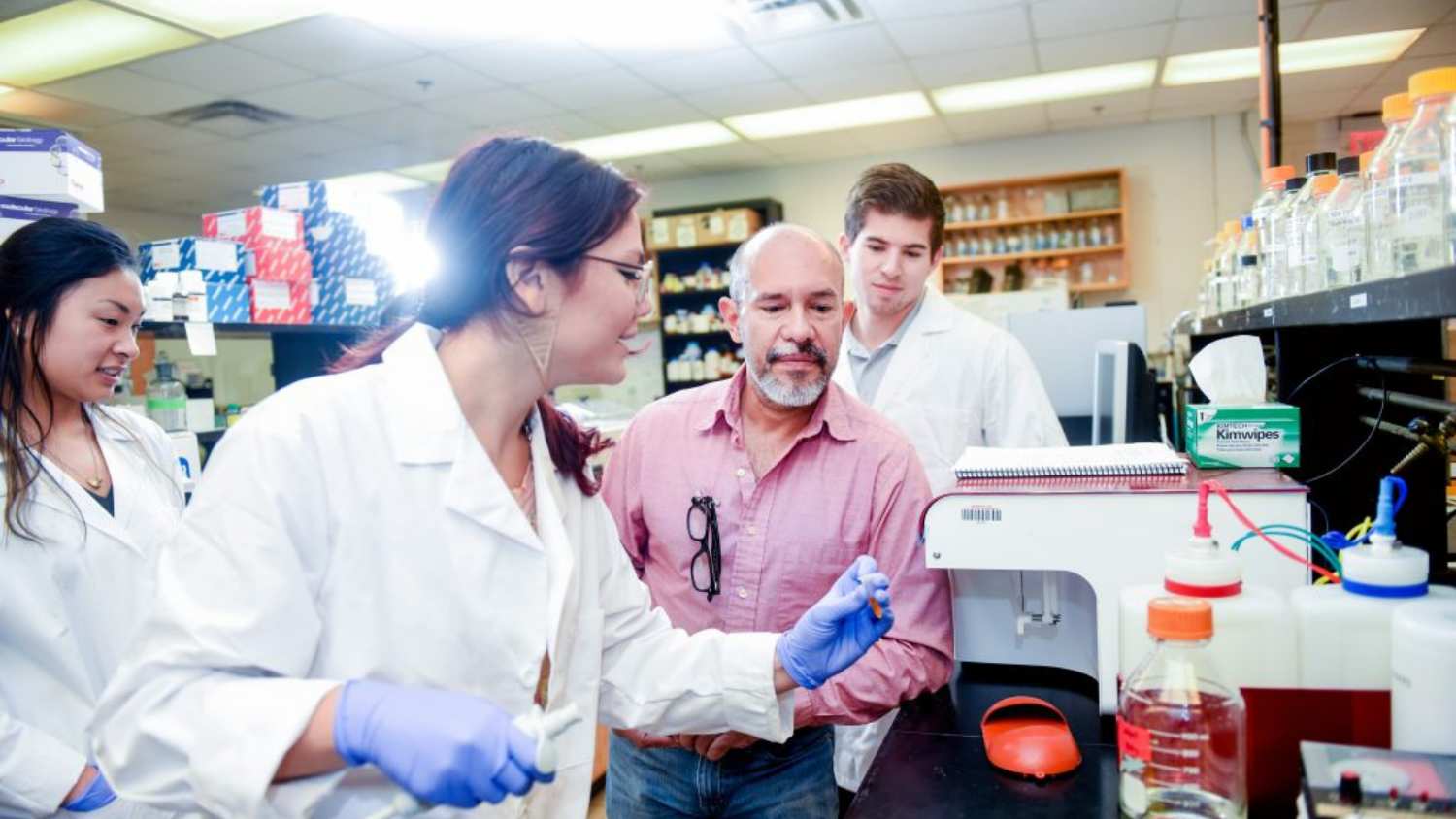 a professor and students discussing in a lab