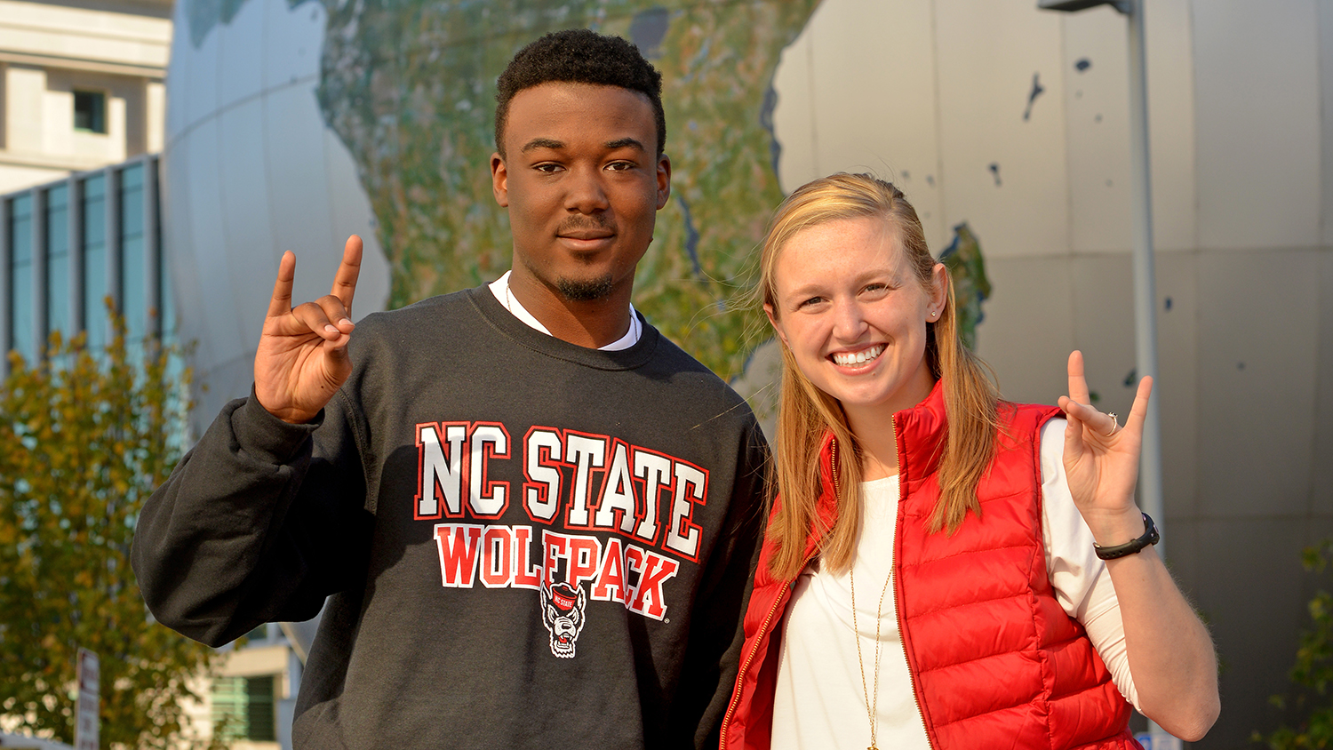 Students giving the Wolfpack sign on campus.