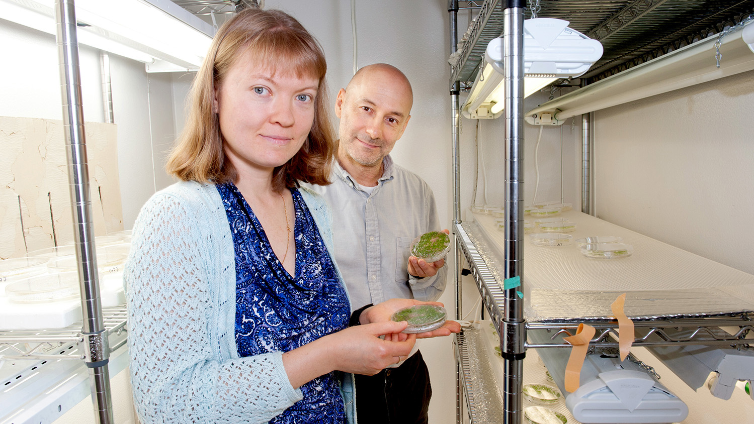 Two scientists, female in foreground and male in background.