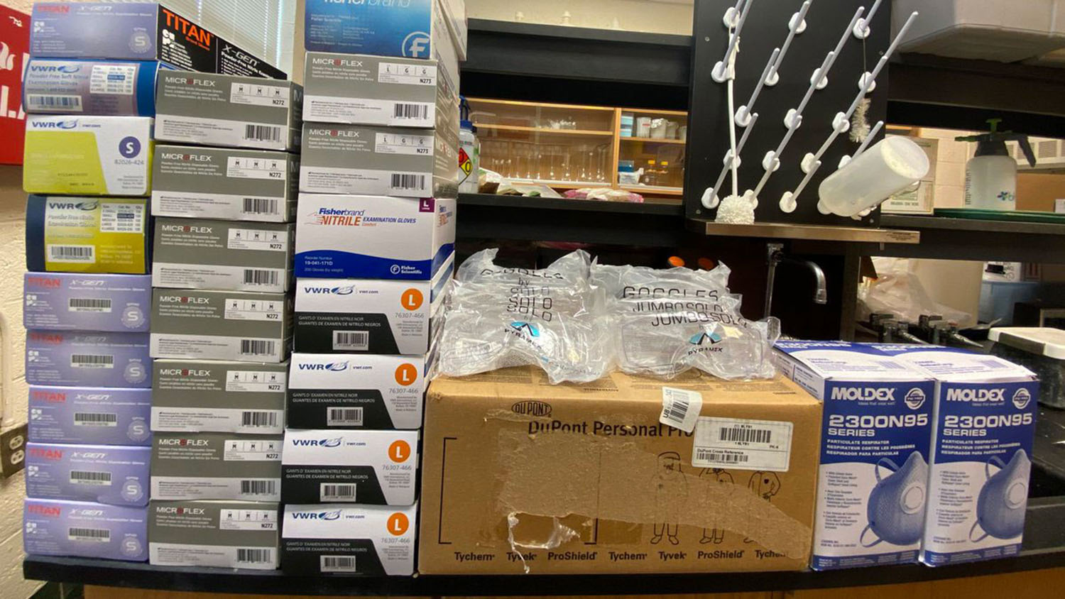 Boxes of gloves, safety goggles and masks in a lab.