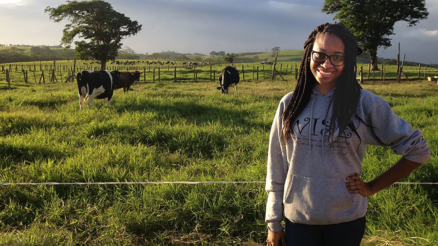 CALS student Nashea Williams standing in front of cows in a field.