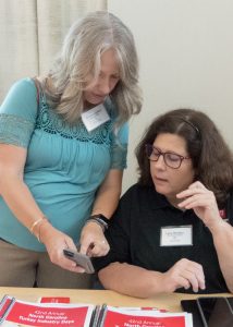 Alumna Summer Lanier shows Lynn Strother her phone