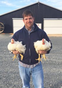 Jonas Asbill holding two broiler chickens
