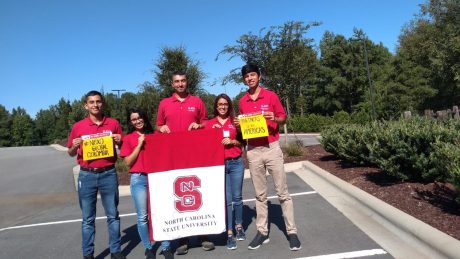 Oviedo lab visiting students holding an NC State banner