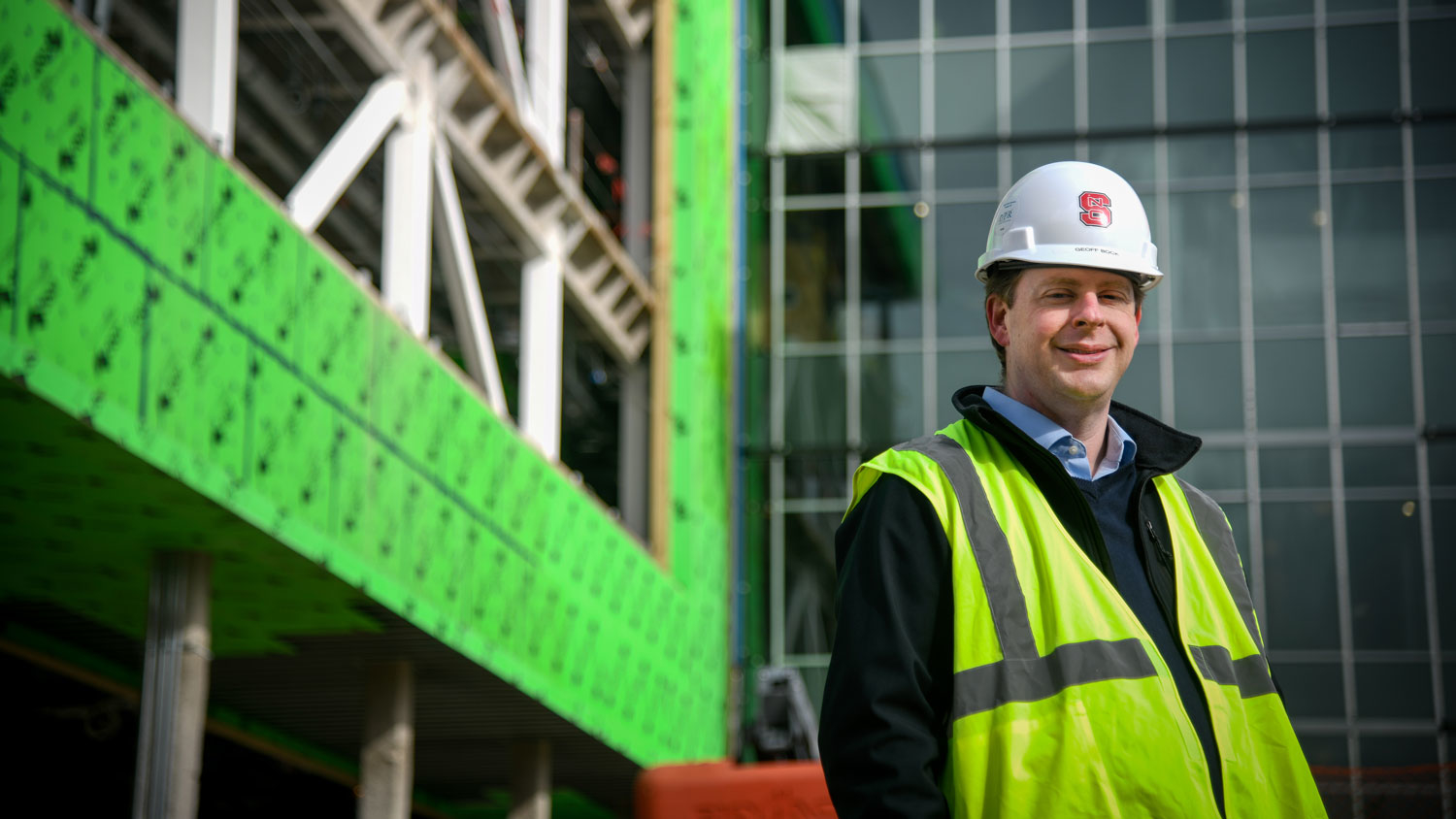 A man wearing a white hard hat at the construction site of the new N.C. PSI building.