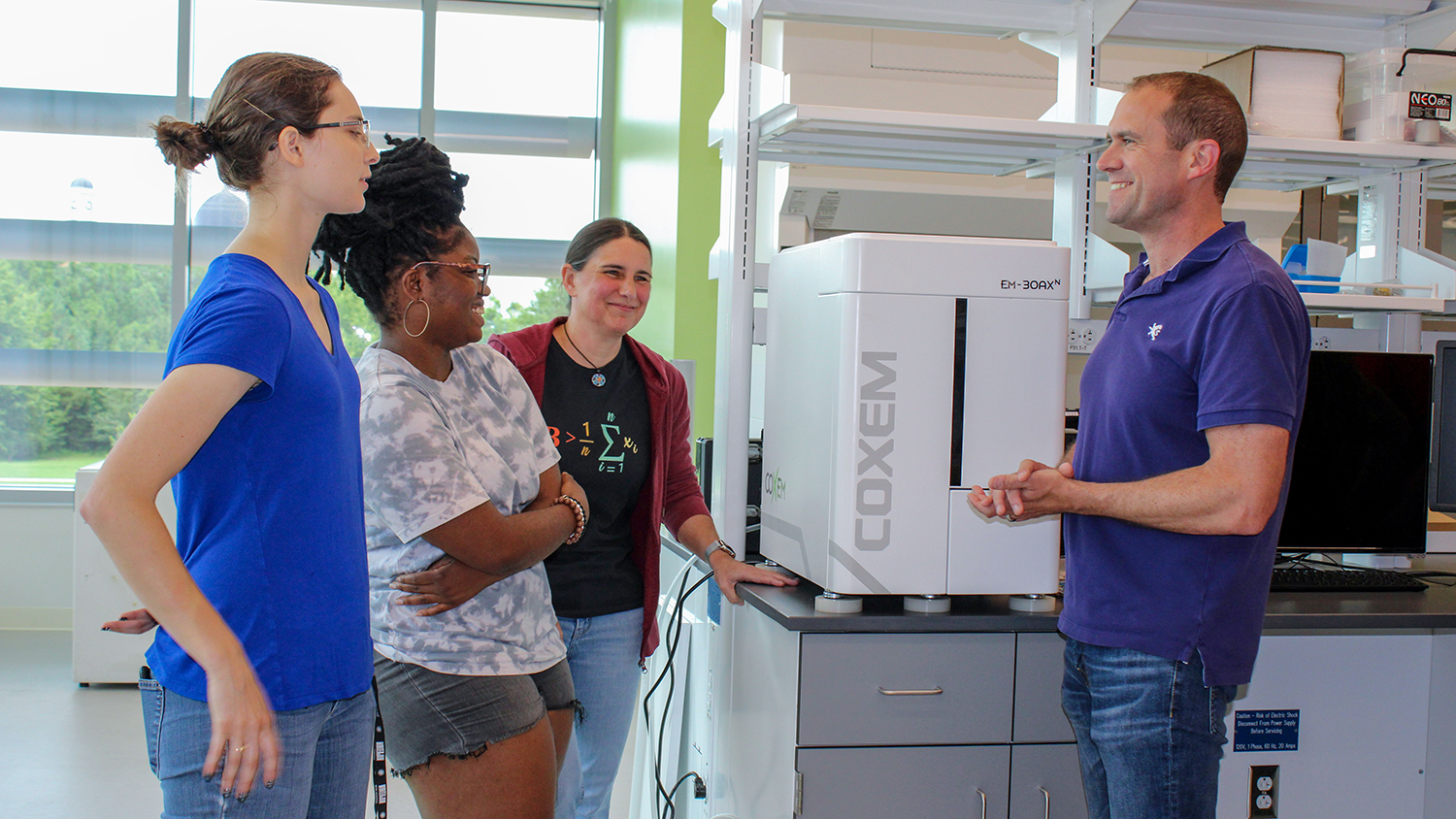 Dr. Jacob Jones, right, talks with three female students in the STEPS lab.