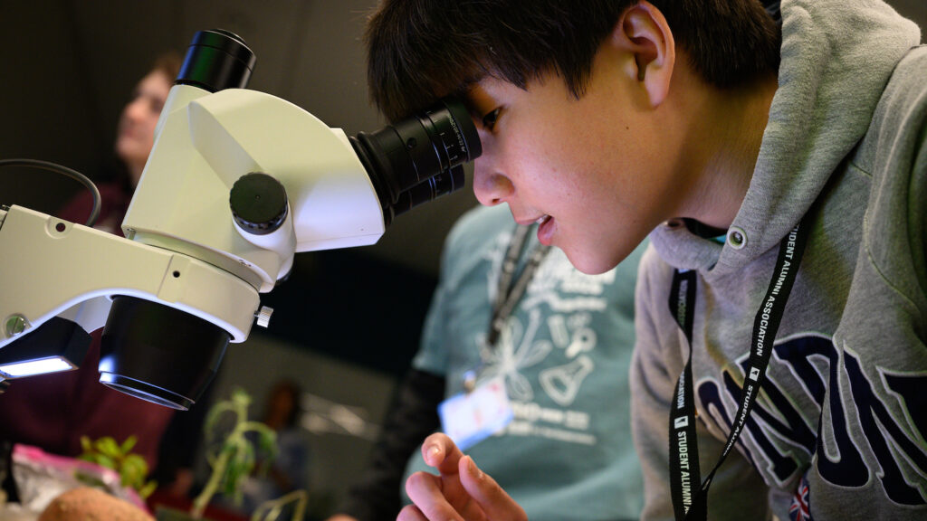Student peering into a microscope