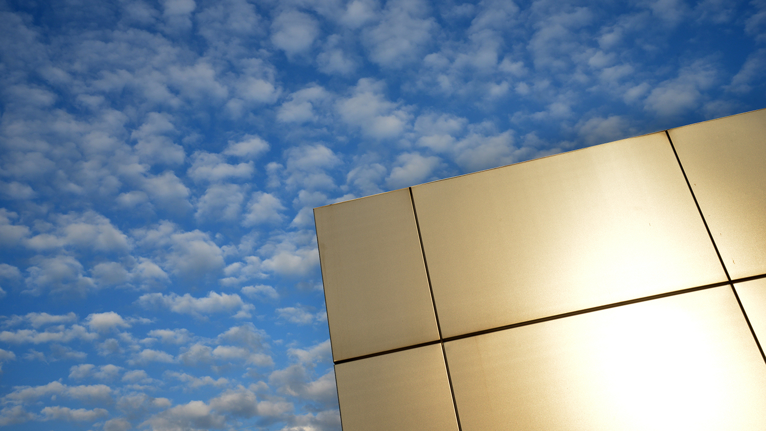 One corner of the Centennial Gateway against a cloud-filled sky