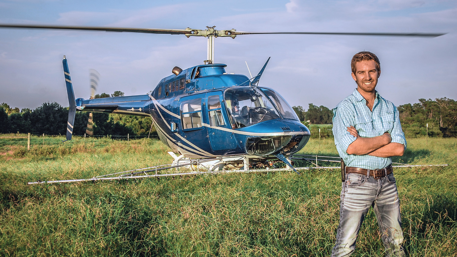 CALS Agricultural Institute graduate Jacob Tarlton in a field with his helicopter.
