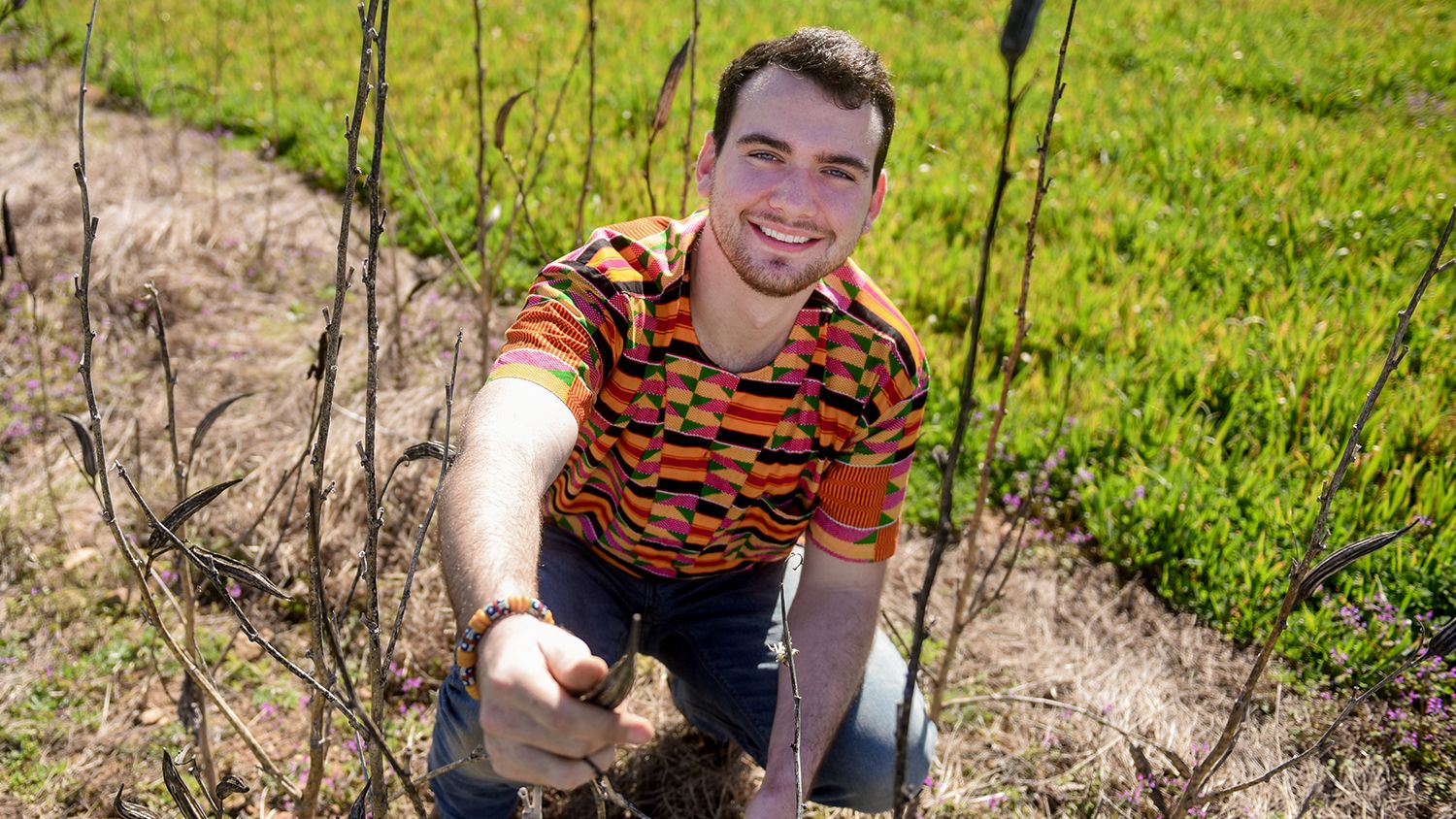 Male student helping build a farm for a school in Africa.