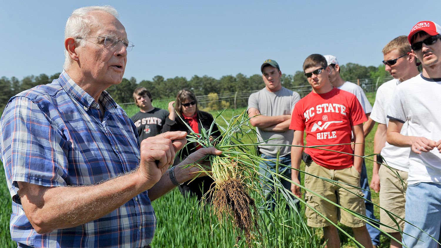Bob Patterson with students outside in an agricultural field.
