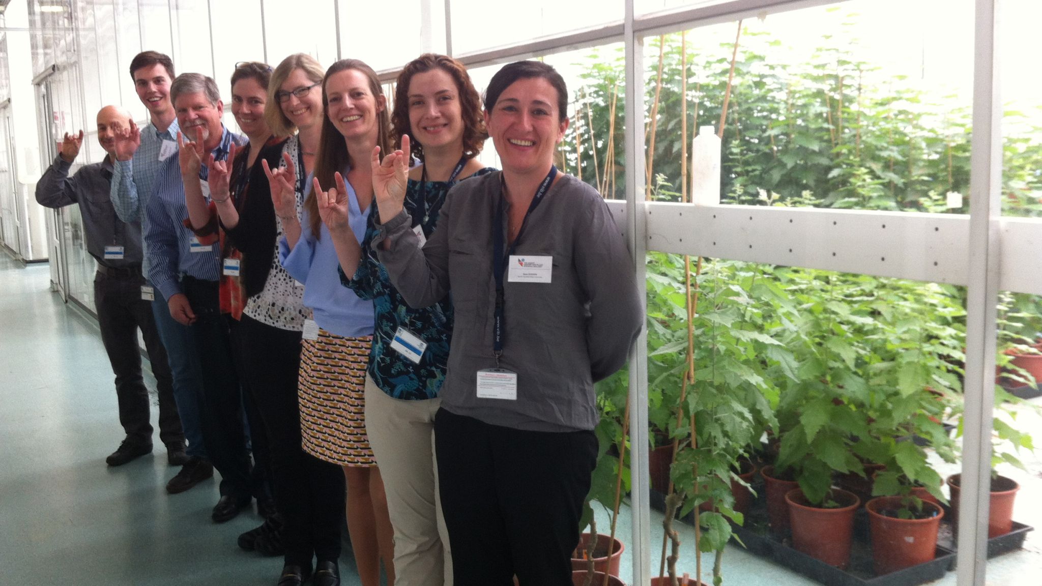 Group of scientists standing outside a greenhouse.