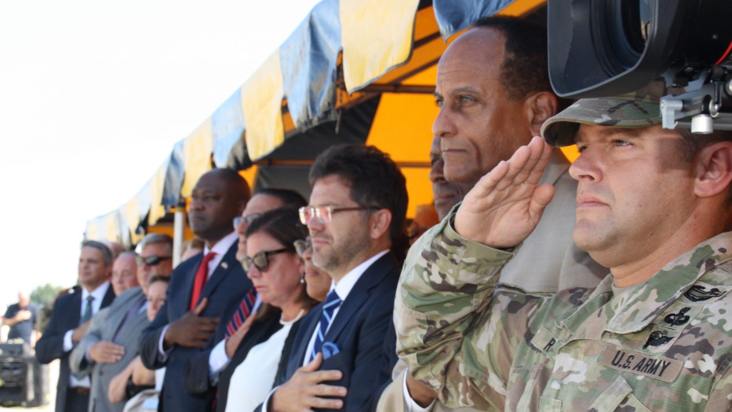 Participants salute the flag during the ribbon cutting ceremony.