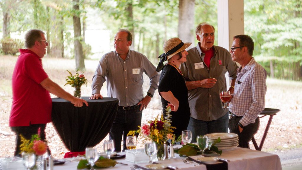 People mingling under a shelter for a fancy feast.