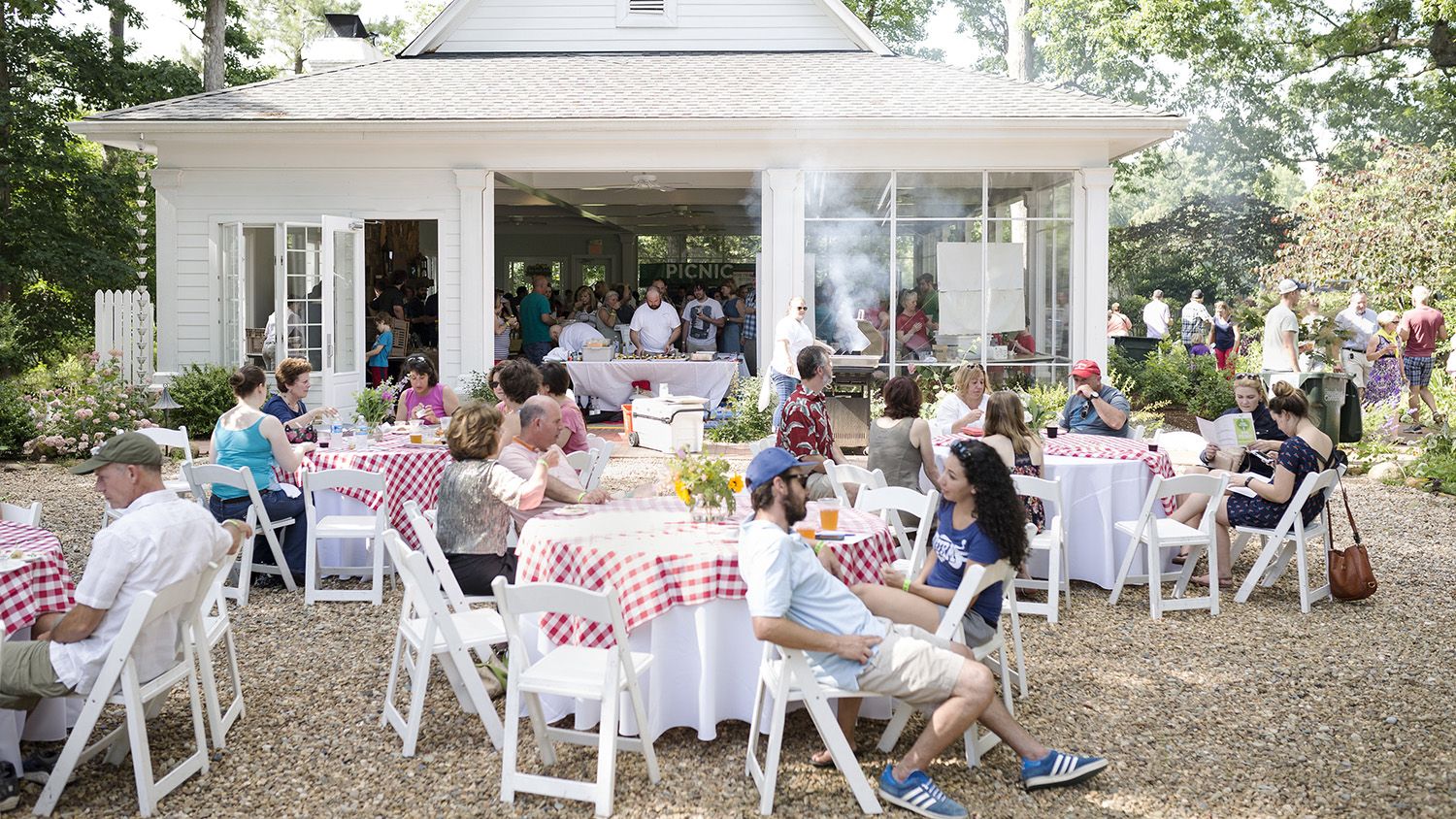 People seated at tables on the grounds of Fearrington Village.