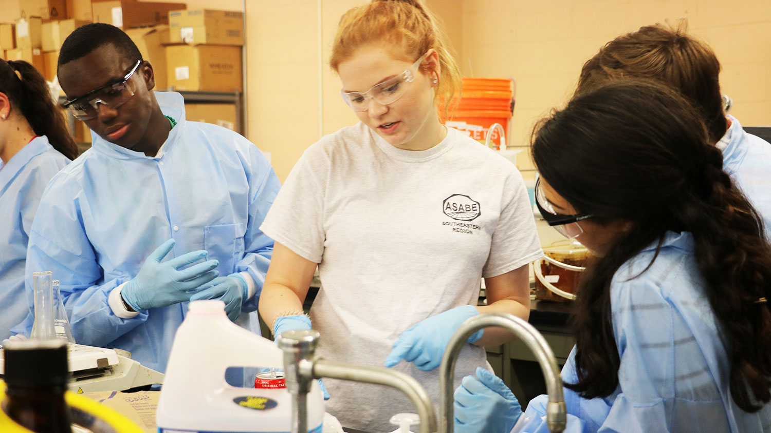 Female student working on an experiment with other students