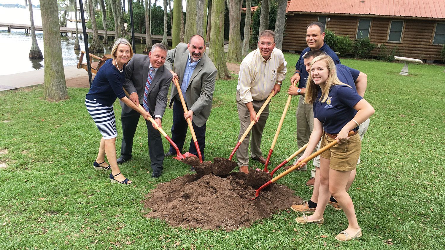 People with shovels gathered around a mound of dirt