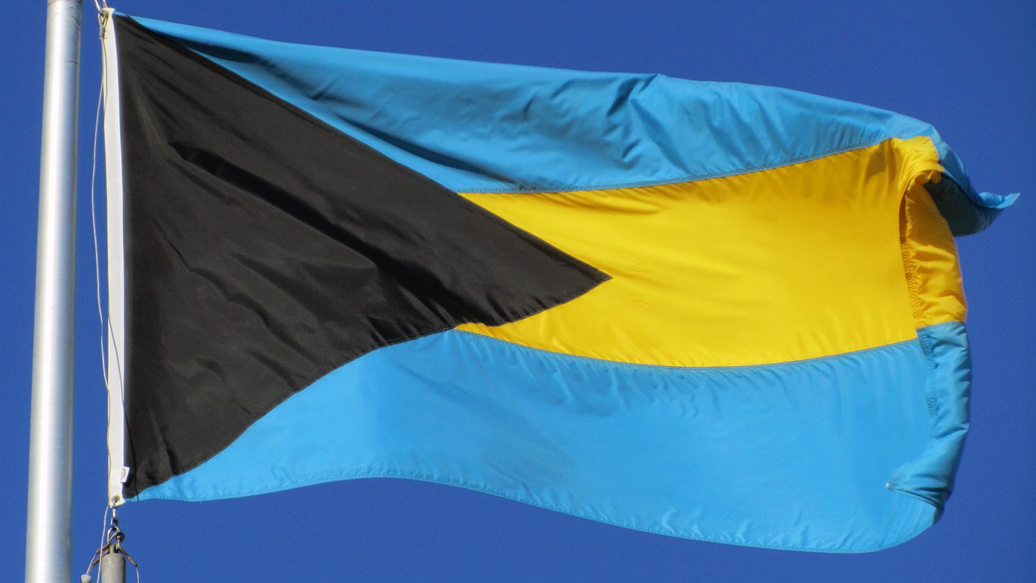 Blue flag with a yellow stripe and black triangle, Bahamas flag