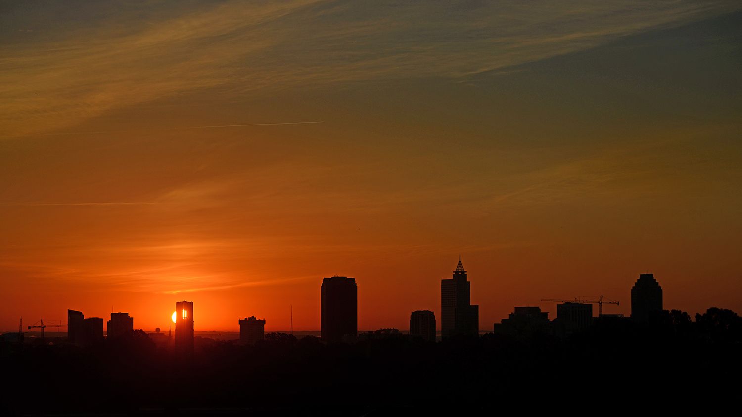 Sun rise silhouettes the Raleigh skyline