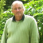 Paul Murphy standing in front of a shrub.