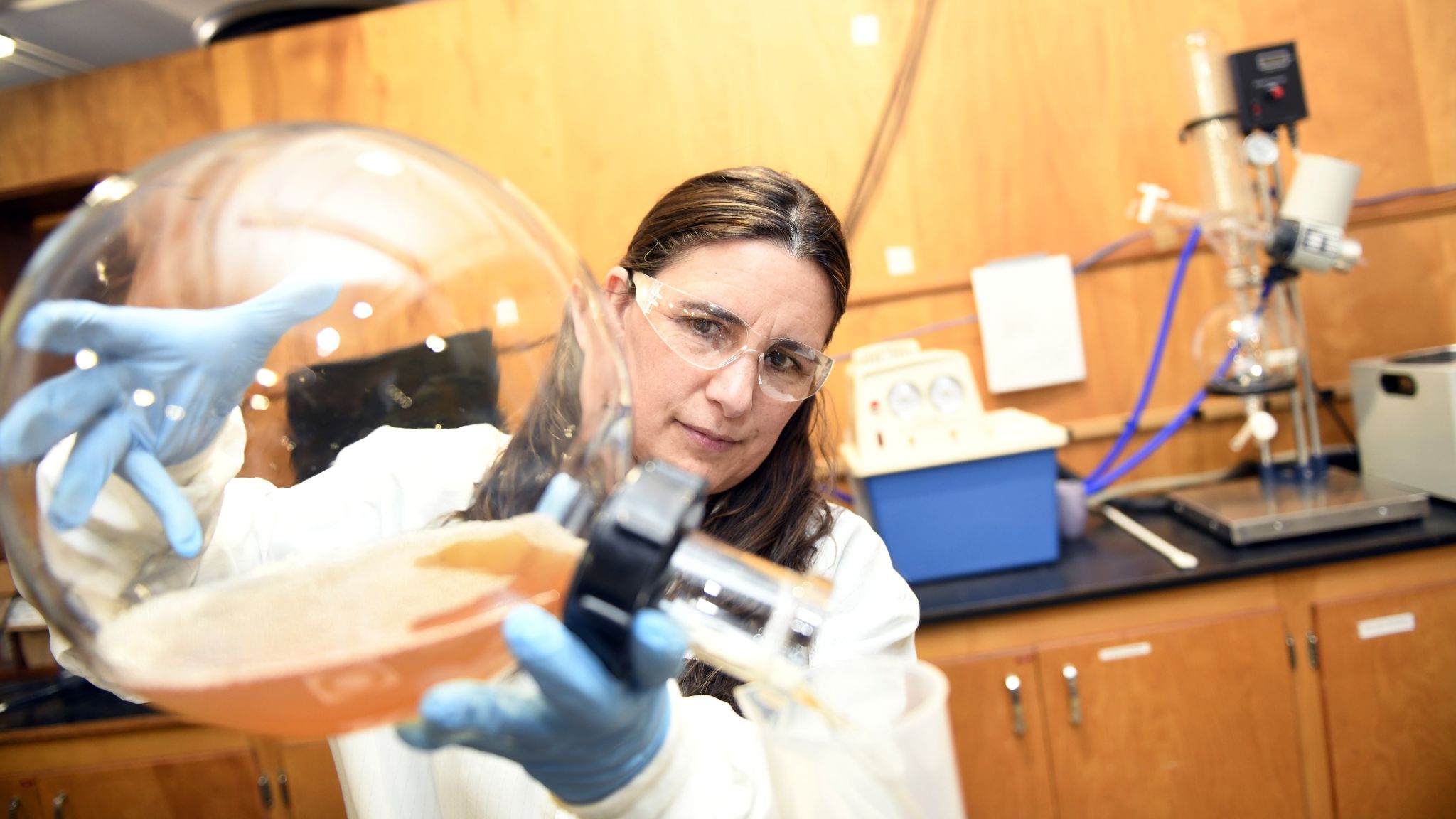 CALS BAE nontraditional student Alison Deviney pours substances from a giant glass beaker.