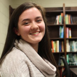 Girl in front of bookshelves