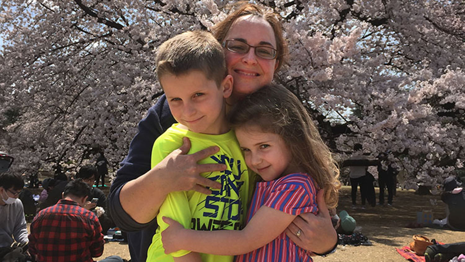 Mom hugging her two kids, one boy one girl