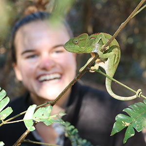 In the foreground, a reptile. In the background, a smiling student