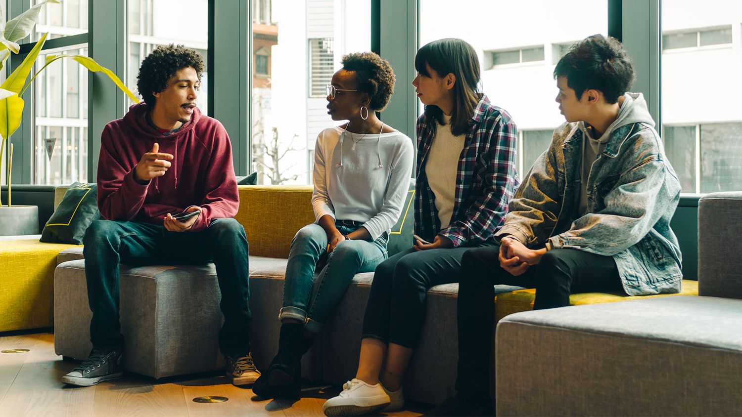 Four students sitting and talking inside